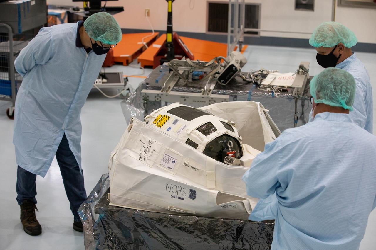 Technicians unpack and inspect a Nitrogen/Oxygen Recharge System (NORS) tank inside the Space Station Processing Facility high bay at NASA’s Kennedy Space Center in Florida on July 16, 2020. The NORS tanks and their support fixtures are designed to connect to the International Space Station’s existing air supply network to refill the previous generation of tanks installed during construction of the space station. These reusable tanks measure 3 feet long and 21 inches in diameter, and weigh about 200 pounds when filled. Once onboard, the tanks will be used to fill the oxygen and nitrogen tanks that supply the needed gases to the space station’s airlock for spacewalks. They could also be used to replenish the atmosphere inside the station. The NORS tanks will launch to the station later in the year on a commercial resupply mission.