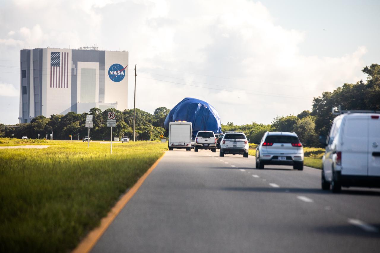 A flatbed truck, carrying the node structural test article (STA), is on its way to the Launch and Landing Facility from the Space Station Processing Facility (SSPF) at NASA’s Kennedy Space Center in Florida on July 20, 2020. In view is the iconic Vehicle Assembly Building. The Node STA was used to prove the manufacturing processes and procedures were robust for extended human spaceflight. Those same processes and procedures were then used to build Node 1, which Kennedy Center Director Bob Cabana flew to the space station on STS 88. NASA has stored the node STA in the SSPF, and it is moving to a new location to allow for more space in the facility’s high bay to support the agency’s space exploration and commercialization efforts in low-Earth orbit.
