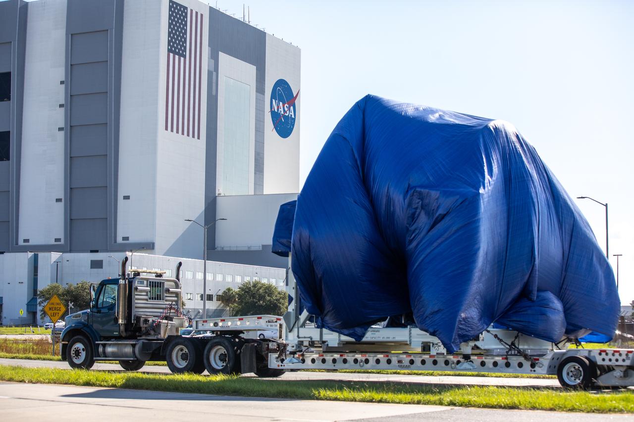 A flatbed truck, carrying the node structural test article (STA), is on its way to the Launch and Landing Facility from the Space Station Processing Facility (SSPF) at NASA’s Kennedy Space Center in Florida on July 20, 2020. In view is the iconic Vehicle Assembly Building. The Node STA was used to prove the manufacturing processes and procedures were robust for extended human spaceflight. Those same processes and procedures were then used to build Node 1, which Kennedy Center Director Bob Cabana flew to the space station on STS 88. NASA has stored the node STA in the SSPF, and it is moving to a new location to allow for more space in the facility’s high bay to support the agency’s space exploration and commercialization efforts in low-Earth orbit.