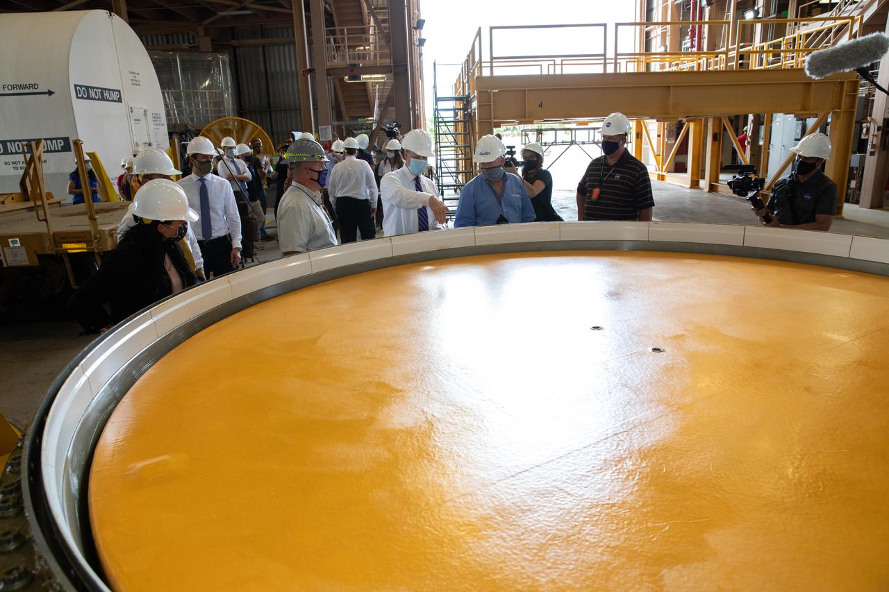 NASA Administrator Jim Bridenstine (center), accompanied by Jacobs and Exploration Ground Systems employees, views Artemis I booster hardware inside the Rotation, Processing and Surge Facility at NASA’s Kennedy Space Center in Florida on July 27, 2020. Manufactured by Northrop Grumman in Utah, the boosters for the agency’s Space Launch System (SLS) rocket are now undergoing prelaunch processing at Kennedy. During launch, the twin boosters will provide more than 75 percent of the total SLS thrust. The first in a series of increasingly complex missions, Artemis I will test the Orion spacecraft and SLS as an integrated system ahead of crewed flights to the Moon.