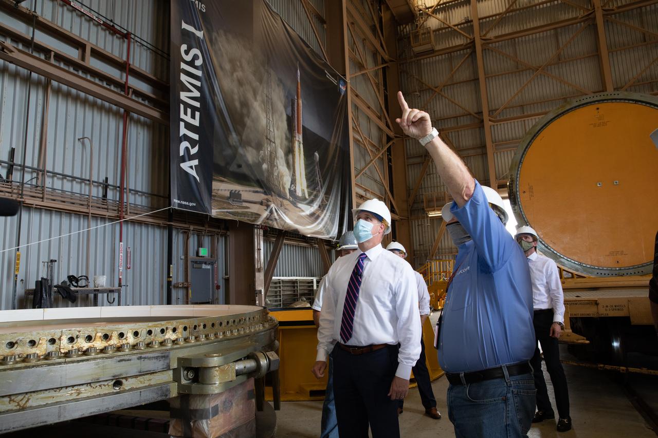 NASA Administrator Jim Bridenstine (left), accompanied by Jacobs employees, views Artemis I booster hardware inside the Rotation, Processing and Surge Facility at NASA’s Kennedy Space Center in Florida on July 27, 2020. Manufactured by Northrop Grumman in Utah, the boosters for the agency’s Space Launch System (SLS) rocket are now undergoing prelaunch processing at Kennedy. During launch, the twin boosters will provide more than 75 percent of the total SLS thrust. The first in a series of increasingly complex missions, Artemis I will test the Orion spacecraft and SLS as an integrated system ahead of crewed flights to the Moon.  