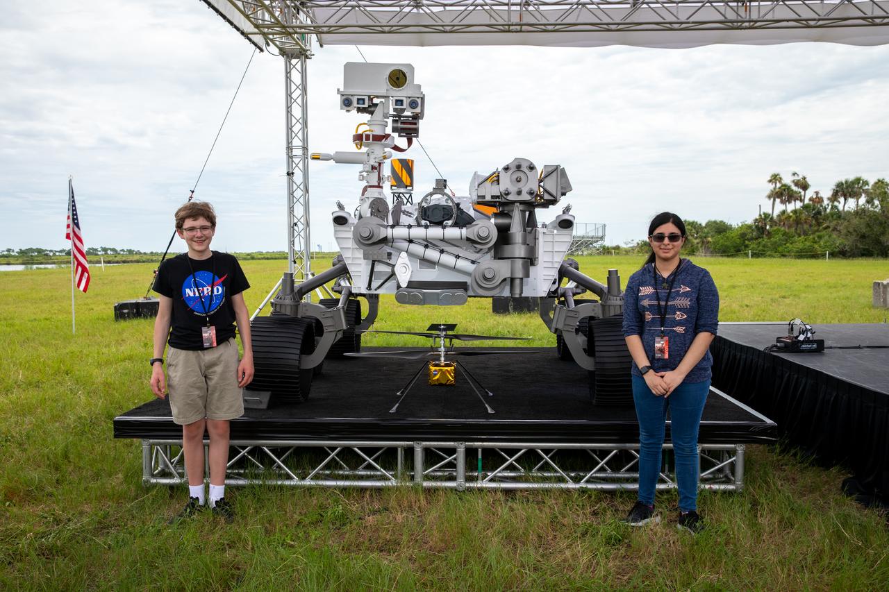 Students Alex Mather, at left, and Vaneeza Rupani, stand near the countdown clock at the News Center at NASA’s Kennedy Space Center in Florida on July 28, 2020. Mather named the Perseverance rover, and Rupani named the Ingenuity helicopter. The rover is scheduled to launch July 30, on a United Launch Alliance Atlas V 541 rocket from Space Launch Complex 41 at nearby Cape Canaveral Air Force Station. The rover is part of NASA’s Mars Exploration Program, a long-term effort of robotic exploration of the Red Planet. The rover will search for habitable conditions in the ancient past and signs of past microbial life on Mars. The Launch Services Program at Kennedy is responsible for launch management. 