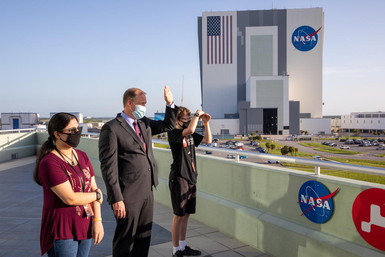 NASA Administrator Jim Bridenstine, center, watches Mars 2020 launch on the observation deck of the Operations and Support Building II at NASA’s Kennedy Space Center in Florida on July 30, 2020. With him are students Vaneeza Rupani, at left, and Alex Mather. Rupani named the Ingenuity helicopter, and Mather names the Mars Perseverance rover. A United Launch Alliance Atlas V 541 rocket lifted off at 7:50 a.m. EDT from Space Launch Complex 41 at nearby Cape Canaveral Air Force Station, sending the rover and helicopter on their trek to Mars. The rover is part of NASA’s Mars Exploration Program, a long-term effort of robotic exploration of the Red Planet. The rover will search for habitable conditions in the ancient past and signs of past microbial life on Mars. The Launch Services Program at Kennedy is responsible for launch management.