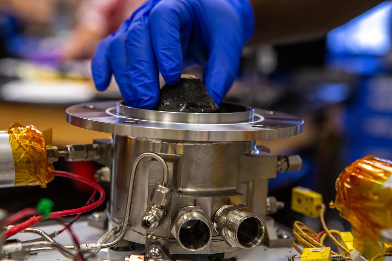 Technicians wearing protective equipment perform work for a future mission on flight hardware for NASA’s Orbital Syngas Commodity Augmentation Reactor, or OSCAR, at the Neil Armstrong Operations and Checkout Facility at the agency’s Kennedy Space Center in Florida on Aug. 10, 2020. OSCAR began as an Early Career Initiative project at the spaceport that studies technology to convert trash and human waste into useful gasses such as methane, hydrogen, and carbon dioxide. By processing small pieces of trash in a high-temperature reactor, OSCAR is advancing new and innovative technology for managing waste in space.