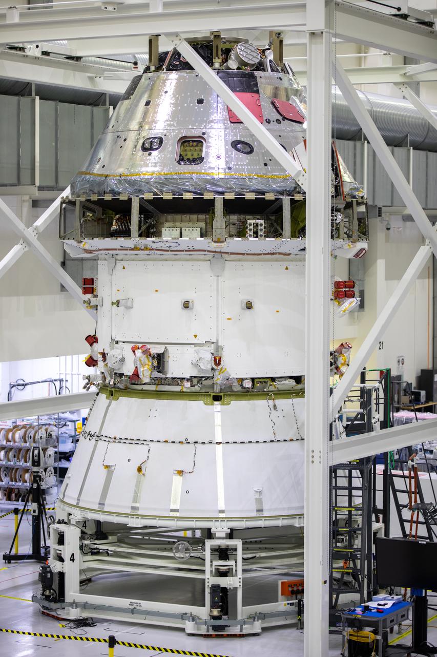 Installation of the spacecraft adapter (SA) cone to the Artemis I Orion spacecraft shown in progress inside the Neil Armstrong Operations and Checkout Building on Aug. 10, 2020. This is one of the final major hardware operations the spacecraft will undergo during closeout processing prior to being integrated with the Space Launch System (SLS) rocket in preparation for the first Artemis mission. The spacecraft adapter cone connects the bottom portion of Orion’s service module to the top part of the rocket known as the interim cryogenic propulsion stage (ICPS). Orion will fly on the agency’s Artemis I mission – the first in a series of increasingly complex missions to the Moon that will ultimately lead to the exploration of Mars.