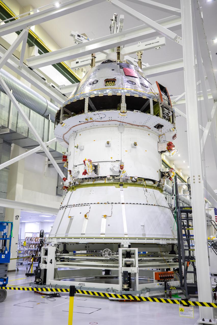 Installation of the spacecraft adapter (SA) cone to the Artemis I Orion spacecraft shown in progress inside the Neil Armstrong Operations and Checkout Building on Aug. 10, 2020. This is one of the final major hardware operations the spacecraft will undergo during closeout processing prior to being integrated with the Space Launch System (SLS) rocket in preparation for the first Artemis mission. The spacecraft adapter cone connects the bottom portion of Orion’s service module to the top part of the rocket known as the interim cryogenic propulsion stage (ICPS). Orion will fly on the agency’s Artemis I mission – the first in a series of increasingly complex missions to the Moon that will ultimately lead to the exploration of Mars.