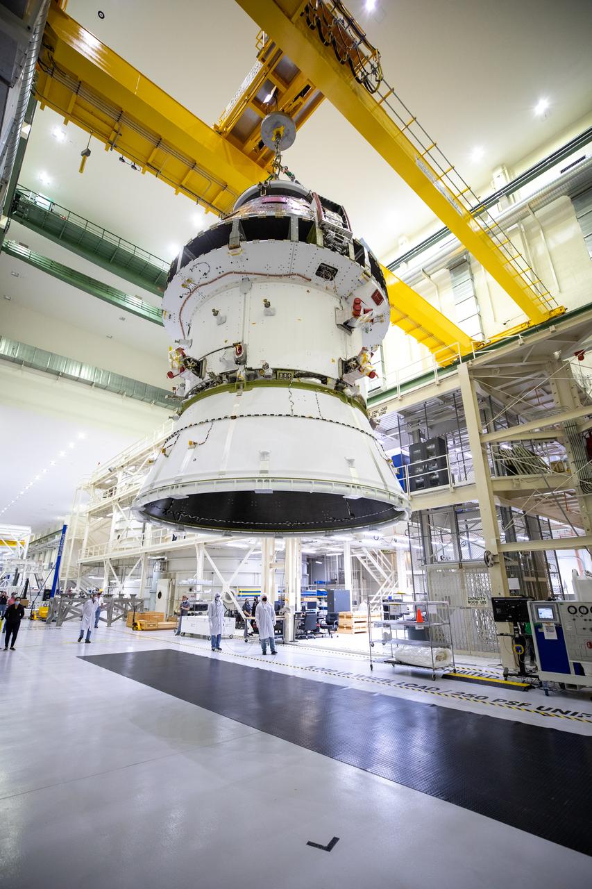 The Artemis I Orion spacecraft with its spacecraft adapter cone attached, is moved by crane along the high bay inside the Neil Armstrong Operations and Checkout Building at NASA’s Kennedy Space Center in Florida on Aug. 20, 2020. This is one of the final major hardware operations the spacecraft will undergo during closeout processing prior to being integrated with the Space Launch System (SLS) rocket in preparation for the first Artemis mission. The spacecraft adapter cone connects the bottom portion of Orion’s service module to the top part of the rocket known as the interim cryogenic propulsion stage (ICPS). Orion will fly on the agency’s Artemis I mission – the first in a series of increasingly complex missions to the Moon that will ultimately lead to the exploration of Mars.