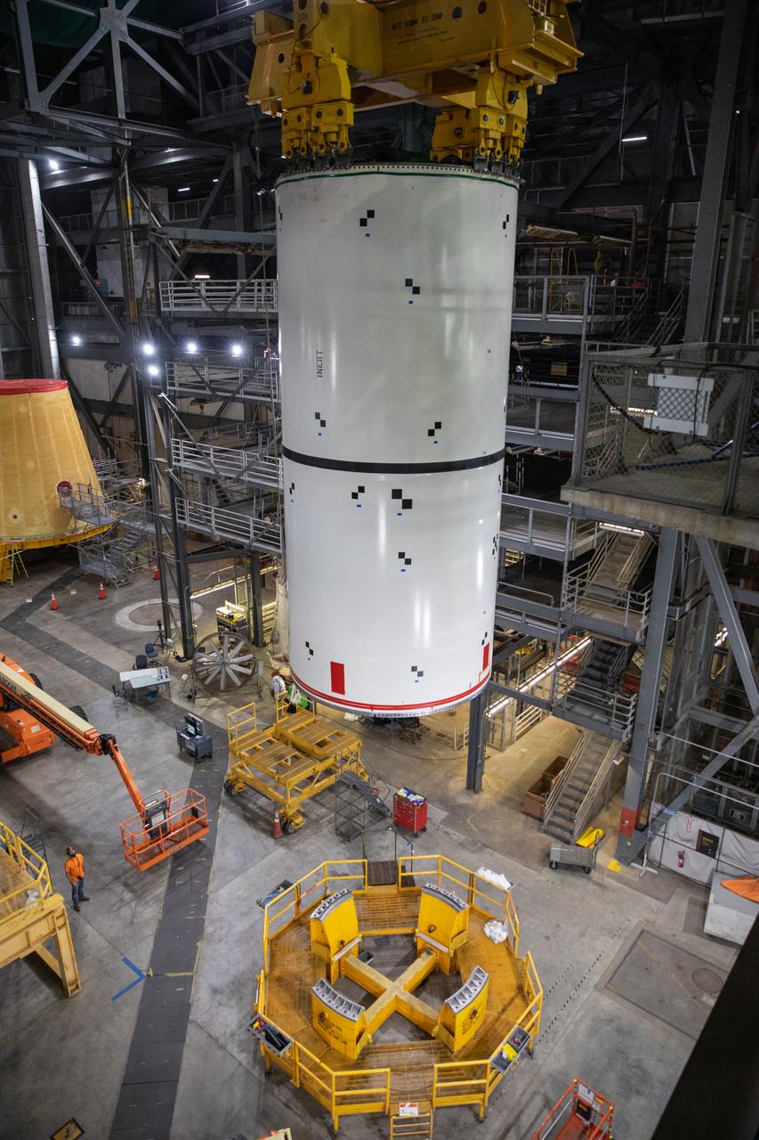 Technicians with NASA’s Exploration Ground Systems rehearse booster stacking operations inside the Vehicle Assembly Building (VAB) at the agency’s Kennedy Space Center in Florida on Sept. 14, 2020, in preparation for Artemis I. The exercise involved using booster segment mock-ups, referred to as pathfinders. During the rehearsal, an aft pathfinder segment was prepared in High Bay 4 of the VAB, after which a team of crane operators moved it over to High Bay 3, where it was placed on the mobile launcher. Careful measurements were then taken before the team added a center pathfinder to the stack. Stacking of the actual Space Launch System (SLS) booster segments will occur later this year, when the rocket’s core stage arrives at Kennedy. Artemis I is the first in a series of increasingly complex missions that will test SLS and the Orion spacecraft as an integrated system prior to crewed flights to the Moon.