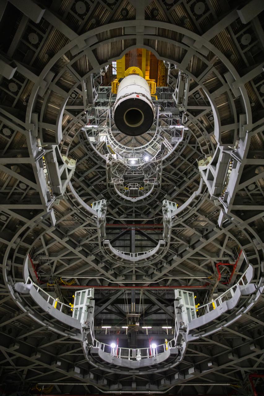 Technicians with NASA’s Exploration Ground Systems prepare to lower a mock-up, or pathfinder, of the Space Launch System’s (SLS) center booster segment onto an aft pathfinder segment inside the Vehicle Assembly Building (VAB) at the agency’s Kennedy Space Center in Florida on Sept. 14, 2020. Teams rehearsed stacking both pathfinder segments on top of the mobile launcher in High Bay 3 of the VAB in preparation for the Artemis I launch. Stacking of the actual SLS booster segments will occur later this year, when the rocket’s core stage arrives at Kennedy. Artemis I is the first in a series of increasingly complex missions that will test SLS and the Orion spacecraft as an integrated system prior to crewed flights to the Moon.