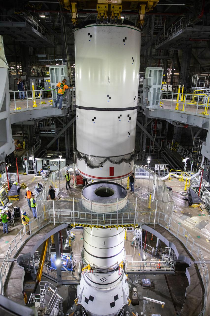 Technicians with NASA’s Exploration Ground Systems lower a mock-up, or pathfinder, of the Space Launch System’s (SLS) center booster segment onto an aft pathfinder segment inside the Vehicle Assembly Building (VAB) at the agency’s Kennedy Space Center in Florida on Sept. 14, 2020. Teams rehearsed stacking both pathfinder segments on top of the mobile launcher in High Bay 3 of the VAB in preparation for the Artemis I launch. Stacking of the actual SLS booster segments will occur later this year, when the rocket’s core stage arrives at Kennedy. Artemis I is the first in a series of increasingly complex missions that will test SLS and the Orion spacecraft as an integrated system prior to crewed flights to the Moon.