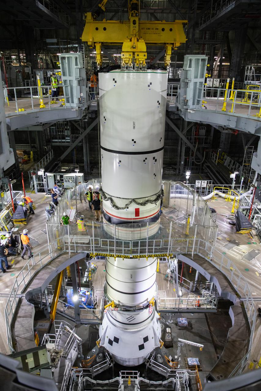 Technicians with NASA’s Exploration Ground Systems lower a mock-up, or pathfinder, of the Space Launch System’s (SLS) center booster segment onto an aft pathfinder segment inside the Vehicle Assembly Building (VAB) at the agency’s Kennedy Space Center in Florida on Sept. 14, 2020. Teams rehearsed stacking both pathfinder segments on top of the mobile launcher in High Bay 3 of the VAB in preparation for the Artemis I launch. Stacking of the actual SLS booster segments will occur later this year, when the rocket’s core stage arrives at Kennedy. Artemis I is the first in a series of increasingly complex missions that will test SLS and the Orion spacecraft as an integrated system prior to crewed flights to the Moon.