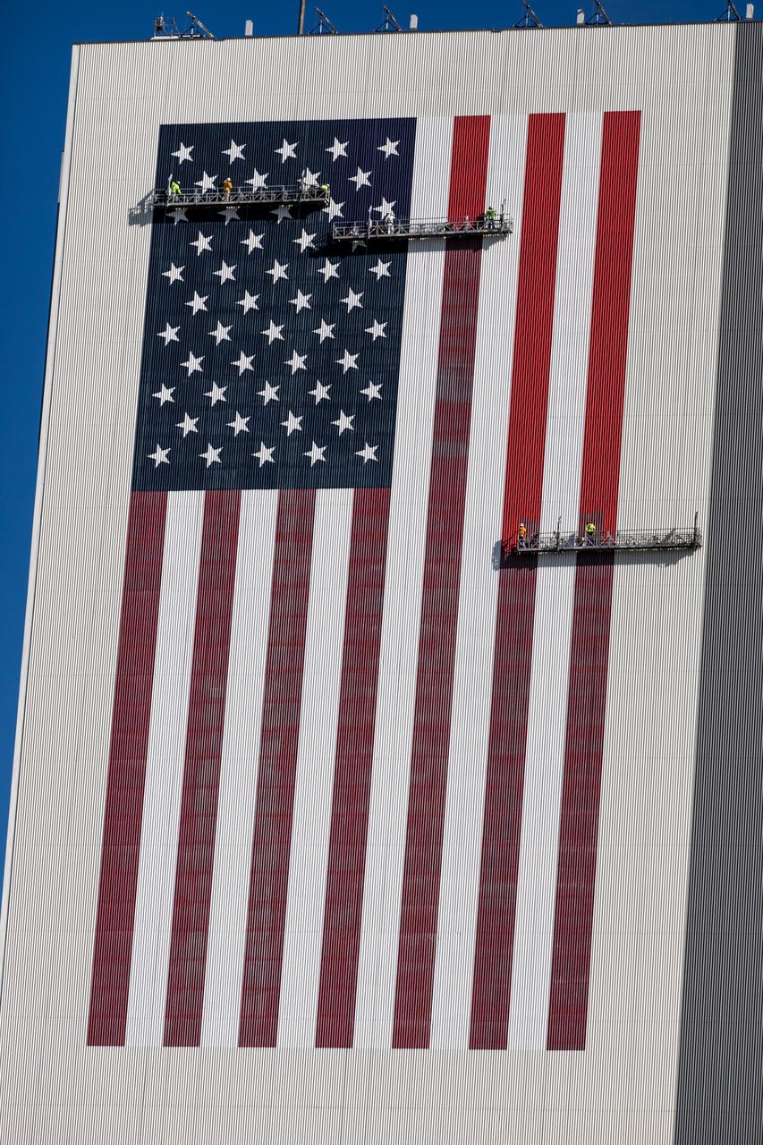 Painting of the U.S. flag continues on the 525-foot-tall Vehicle Assembly Building (VAB) at NASA’s Kennedy Space Center in Florida on Sept. 17, 2020. HM2 and H.I.S. Painting of Titusville, Florida, are repainting the American Flag on the iconic building. The flag is 209 feet long by 110 feet wide. Each star is more than six feet in diameter, and each stripe is nine feet wide. Exploration Ground Systems is overseeing upgrades to the VAB to support the launch of the Space Launch System and Orion for Artemis missions. Under the Artemis program, NASA will send the first woman and next man to the Moon.