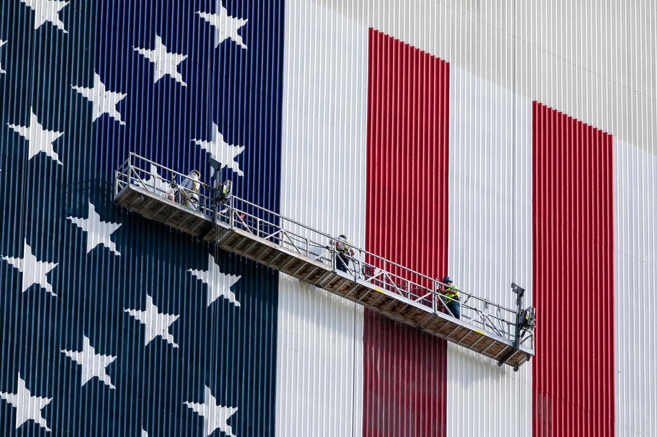 Painting of the U.S. flag continues on the 525-foot-tall Vehicle Assembly Building (VAB) in this close-up view at NASA’s Kennedy Space Center in Florida on Sept. 17, 2020. HM2 and H.I.S. Painting of Titusville, Florida, are repainting the American Flag on the iconic building. The flag is 209 feet long by 110 feet wide. Each star is more than six feet in diameter, and each stripe is nine feet wide. Exploration Ground Systems is overseeing upgrades to the VAB to support the launch of the Space Launch System and Orion for Artemis missions. Under the Artemis program, NASA will send the first woman and next man to the Moon.