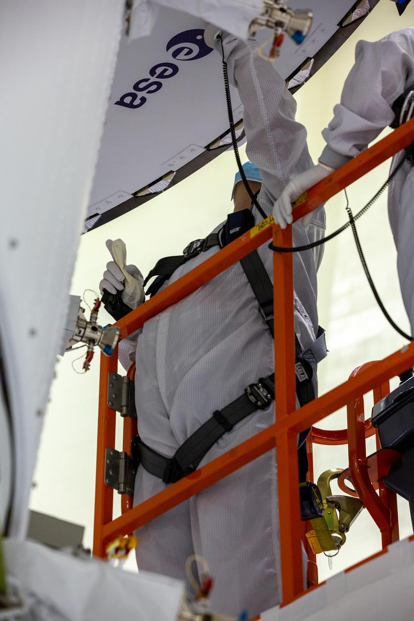 Inside the Neil Armstrong Operations and Checkout Building high bay at Kennedy Space Center, ASRC technician Frank Pelkey works to adhere the European Space Agency (ESA) logo to the aft wall of Orion’s crew module adapter on Sept. 20, 2020, ahead of NASA’s Artemis I mission. The first in a series of increasingly complex missions, Artemis I will test the Orion spacecraft and Space Launch System as an integrated system ahead of crewed flights to the Moon. Under the Artemis program, NASA will land the first woman and the next man on the Moon by 2024.