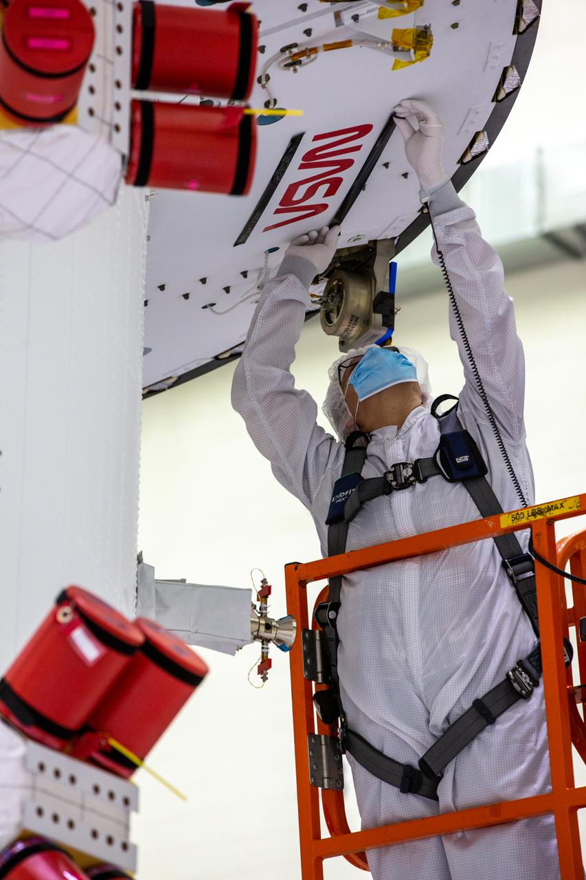 Frank Pelkey, ASRC technician, adheres removable tape around NASA’s iconic “worm” logo decal on the aft wall of Orion’s crew module adapter ahead of NASA’s Artemis I mission. The work is complete inside the Neil Armstrong Operations and Checkout Building high bay at Kennedy Space Center on Sept. 20, 2020.  Originally created by the firm of Danne & Blackburn, the “worm” logo’s bold, sleek design was officially introduced in 1975 and was incorporated into many of the agency’s next-generation programs. It was retired in 1992, but has made a comeback in 2020 as the agency ushers in a new, modern era of human spaceflight. The first in a series of increasingly complex missions, Artemis I will test the Orion spacecraft and Space Launch System as an integrated system ahead of crewed flights to the Moon. Under the Artemis program, NASA will land the first woman and the next man on the Moon by 2024.