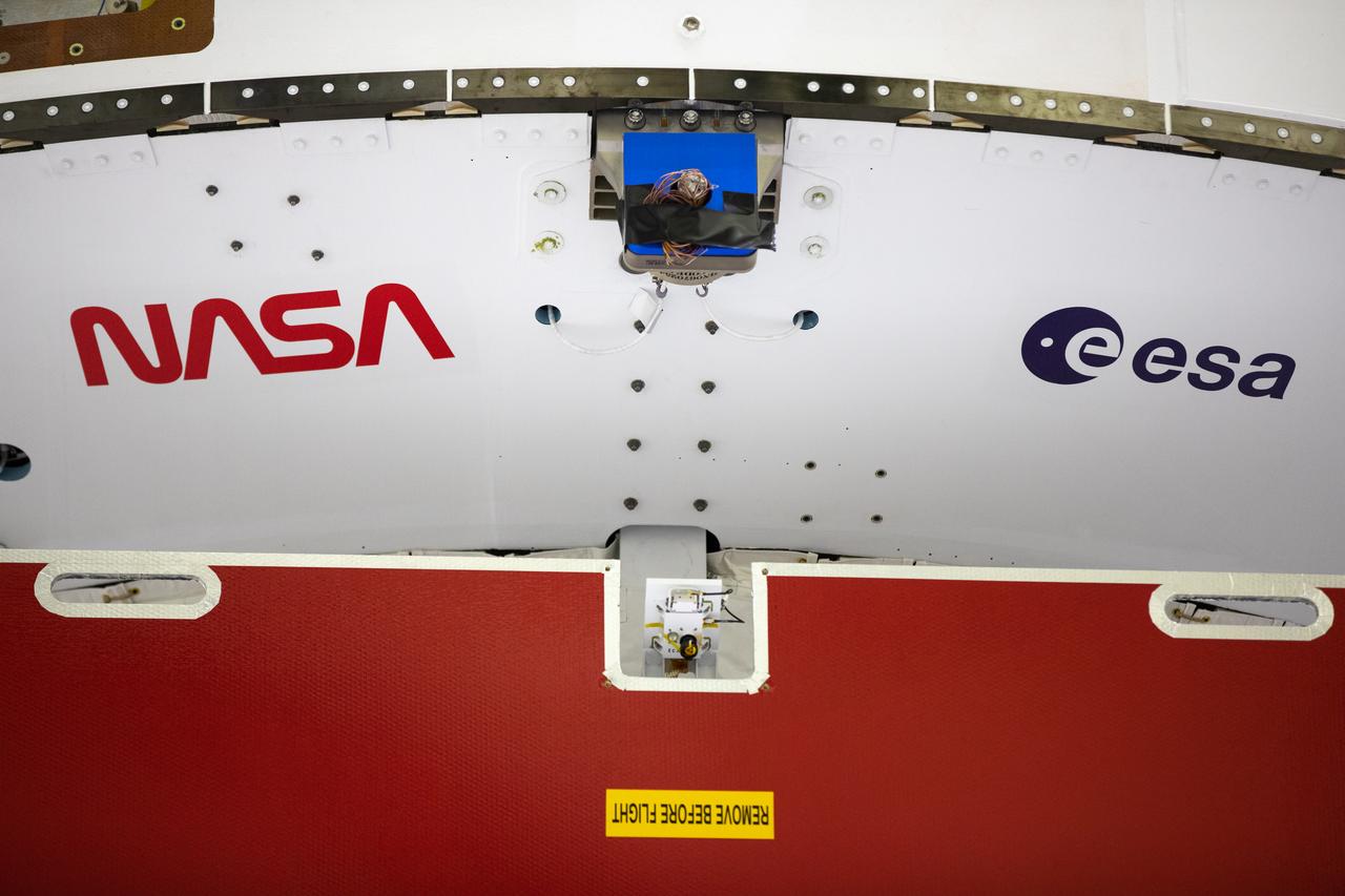 Inside the Neil Armstrong Operations and Checkout Building high bay at Kennedy Space Center, NASA’s iconic “worm” logo and European Space Agency (ESA) logo have been added to the aft wall of Orion’s crew module adapter ahead of NASA’s Artemis I mission. Originally created by the firm of Danne & Blackburn, the “worm” logo’s bold, sleek design was officially introduced in 1975 and was incorporated into many of the agency’s next-generation programs. It was retired in 1992, but has made a comeback in 2020 as the agency ushers in a new, modern era of human spaceflight. The Orion spacecraft is being prepared for installation of the solar array wings on Sept. 23, 2020. The first in a series of increasingly complex missions, Artemis I will test the Orion spacecraft and Space Launch System as an integrated system ahead of crewed flights to the Moon. Under the Artemis program, NASA will land the first woman and the next man on the Moon by 2024.