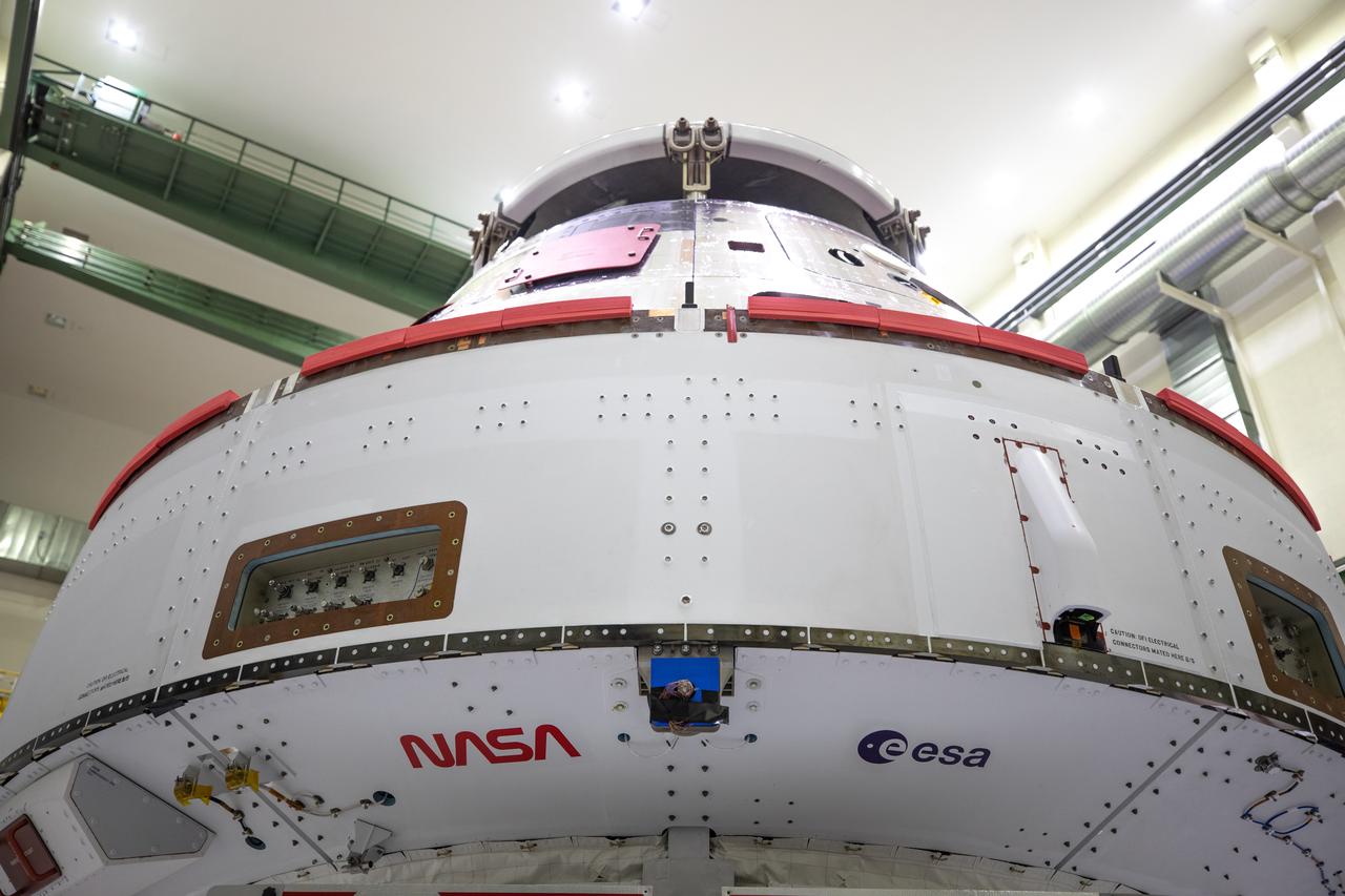Inside the Neil Armstrong Operations and Checkout Building high bay at Kennedy Space Center, NASA’s iconic “worm” logo and European Space Agency (ESA) logo have been added to the aft wall of Orion’s crew module adapter ahead of NASA’s Artemis I mission. Originally created by the firm of Danne & Blackburn, the “worm” logo’s bold, sleek design was officially introduced in 1975 and was incorporated into many of the agency’s next-generation programs. It was retired in 1992, but has made a comeback in 2020 as the agency ushers in a new, modern era of human spaceflight. The Orion spacecraft is being prepared for installation of the solar array wings on Sept. 23, 2020. The first in a series of increasingly complex missions, Artemis I will test the Orion spacecraft and Space Launch System as an integrated system ahead of crewed flights to the Moon. Under the Artemis program, NASA will land the first woman and the next man on the Moon by 2024.