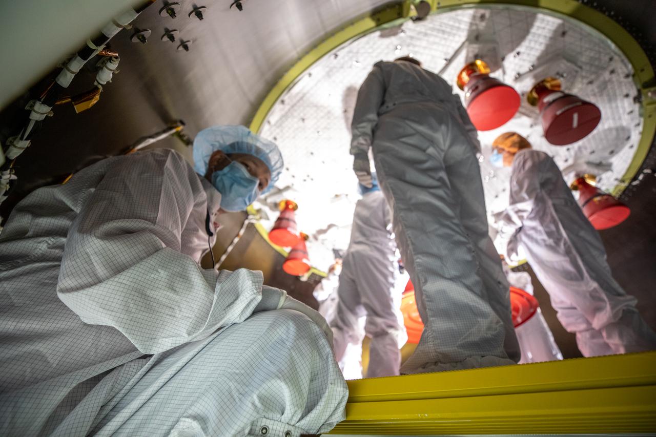 Members of the European Service Module processing team from the European Space Agency and Airbus inspect the insulation on the underside of the Orion service module for Artemis I inside the Neil Armstrong Operations and Checkout Building high bay at NASA’s Kennedy Space Center in Florida on Sept. 23, 2020. Work is also underway to attach protective covers over the solar arrays wings that were installed on the service module. Each solar array panel will generate 11 kilowatts of power and span about 63 feet. The array is a component of Orion’s service module, which is provided by the European Space Agency and built by Airbus Defence and Space to supply Orion’s power, propulsion, air and water. The first in a series of increasingly complex missions, Artemis I will test the Orion spacecraft and Space Launch System as an integrated system ahead of crewed flights to the Moon. Under the Artemis program, NASA will land the first woman and the next man on the Moon in 2024.