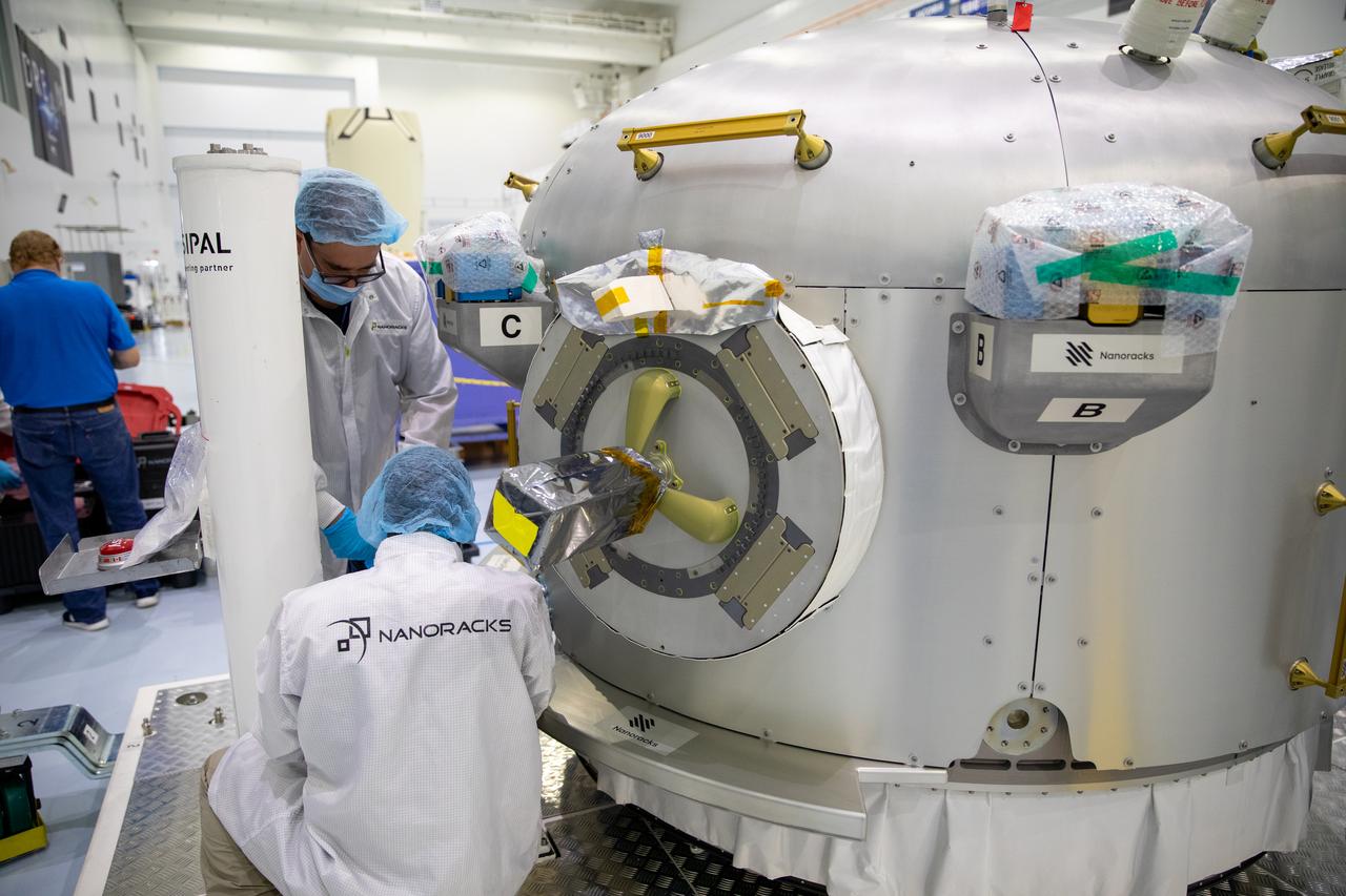 Nanoracks technicians work on the NanoRacks Bishop Airlock inside the Space Station Processing Facility at NASA's Kennedy Space Center in Florida on Sept. 29, 2020. The next-generation Nanoracks payload facility is being prepared for its flight to the International Space Station on SpaceX’s 21st commercial resupply services mission (CRS-21) to the International Space Station. The Bishop Airlock is the first commercially funded airlock for the space station. It will provide payload hosting, robotics testing, satellite deployment, serve as an outside toolbox for station crew spacewalks, and more. CRS-21 is scheduled to launch on a SpaceX Falcon 9 rocket no earlier than November from Launch Complex 39A at Kennedy Space Center.