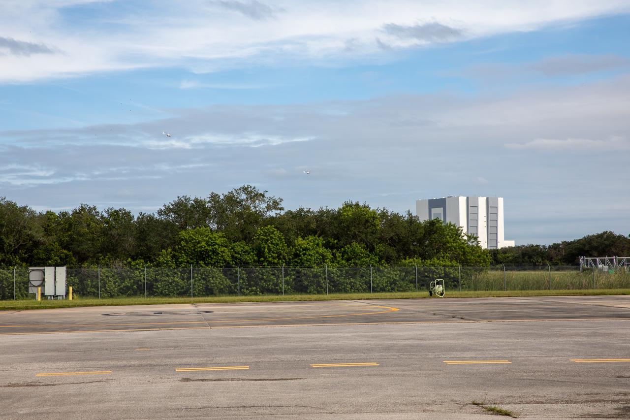 Two new Airbus H135 (T3) helicopters can be seen in the distance, arriving at the Launch and Landing Facility runway at NASA’s Kennedy Space Center in Florida on Sept. 30, 2020. The H135 helicopters will replace the Bell Huey 2 security aircraft in service now, maintained by Kennedy’s Flight Operations team. These new helicopters provide a number of technological and safety advantages over the Hueys, such as more lifting power, greater stability in the air, and expanded medical capabilities. The team expects to fully transition to flying the two H135s later this year. A third is expected to arrive in early 2021, and with its arrival, will complete the fleet’s upgrade.