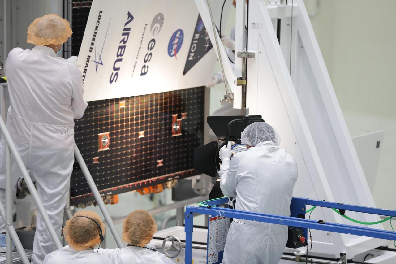 Technicians with the European Space Agency and Airbus/Airbus Netherlands are shown performing an illumination test on one of the solar array wing panels during installation on the Orion spacecraft for Artemis I inside the Neil Armstrong Operations and Checkout Building high bay at NASA’s Kennedy Space Center in Florida on Sept. 30, 2020. The solar arrays were extended, inspected, and then retracted, before installation on the spacecraft. Each solar array panel will generate 11 kilowatts of power and span about 63 feet. The array is a component of Orion’s service module, which is provided by the European Space Agency and built by Airbus Defence and Space to supply Orion’s power, propulsion, air and water. The first in a series of increasingly complex missions, Artemis I will test the Orion spacecraft and Space Launch System as an integrated system ahead of crewed flights to the Moon. Under the Artemis program, NASA will land the first woman and the next man on the Moon in 2024.