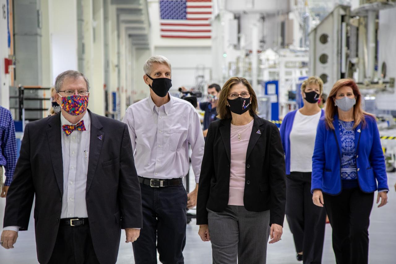 Catherine Koerner, in the center, NASA Orion Program manager, along with senior managers from Orion and Lockheed Martin, tour the Neil Armstrong Operations and Checkout Building at NASA’s Kennedy Space Center in Florida on Oct. 6, 2020. Accompanying her, from left are Mike Hawes, Lockheed Martin vice president and Orion Program manager; Scott Wilson, NASA Kennedy Orion Production Operations manager; Annette Hasbrook, Orion Program assistant manager; and Kelly DeFazio, Lockheed Martin vehicle production director on the Orion Production Operations Contract. Koerner viewed Orion spacecraft for the Artemis I and II missions. In view in the background, at right, is one of three Spacecraft Adapter Jettison fairing panels to be installed on the spacecraft. The first in a series of increasingly complex missions, Artemis I will test the Orion spacecraft and Space Launch System as an integrated system ahead of crewed flights to the Moon. Under the Artemis program, NASA will land the first woman and the next man on the Moon in 2024.