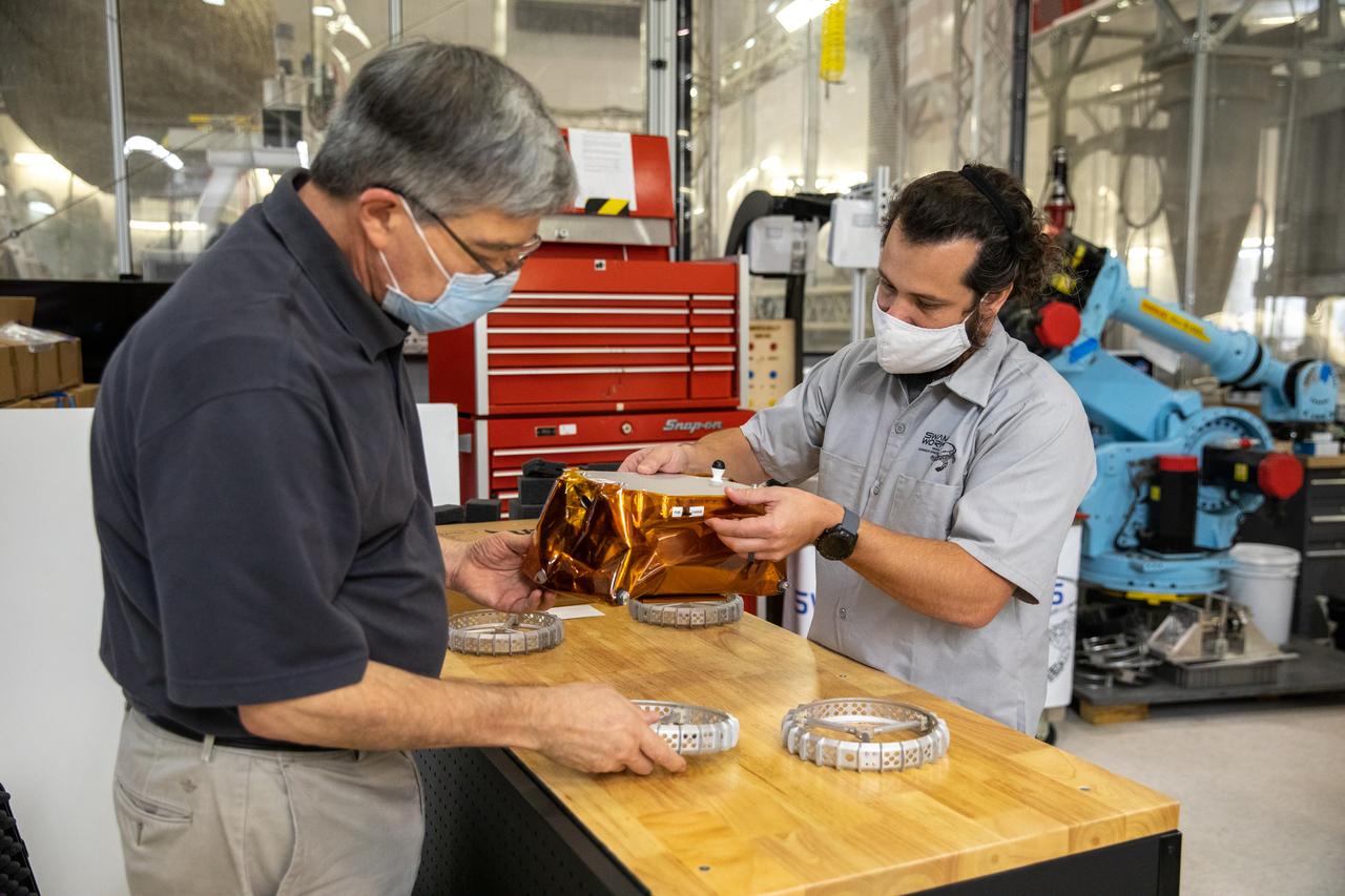 Jim Mantovani, left, and A.J. Nick, with Kennedy Space Center’s Exploration and Research and Technology programs, unbox a CubeRover at the Florida spaceport on Oct. 9, 2020. The rover was delivered by Pittsburgh-based space robotics company Astrobotic, as part of a Small Business Innovative Research (SBIR) award from NASA. Nick will lead CubeRover testing in the coming months in the Granular Mechanics and Regolith Operations (GMRO) Laboratory’s regolith bin, which holds approximately 120 tons of lunar regolith simulant at Kennedy’s Swamp Works. In 2019, NASA announced a $2 million Tipping Point award to develop more mature CubeRover’s payload interfaces and increase its capabilities.