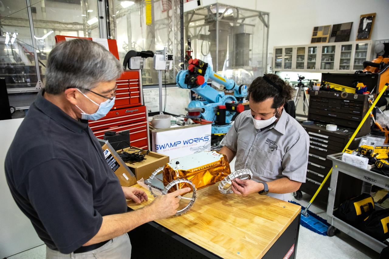 Jim Mantovani, left, and A.J. Nick, with Kennedy Space Center’s Exploration and Research and Technology programs, unbox a CubeRover at the Florida spaceport on Oct. 9, 2020. The rover was delivered by Pittsburgh-based space robotics company Astrobotic, as part of a Small Business Innovative Research (SBIR) award from NASA. Nick will lead CubeRover testing in the coming months in the Granular Mechanics and Regolith Operations (GMRO) Laboratory’s regolith bin, which holds approximately 120 tons of lunar regolith simulant at Kennedy’s Swamp Works. In 2019, NASA announced a $2 million Tipping Point award to develop more mature CubeRover’s payload interfaces and increase its capabilities.