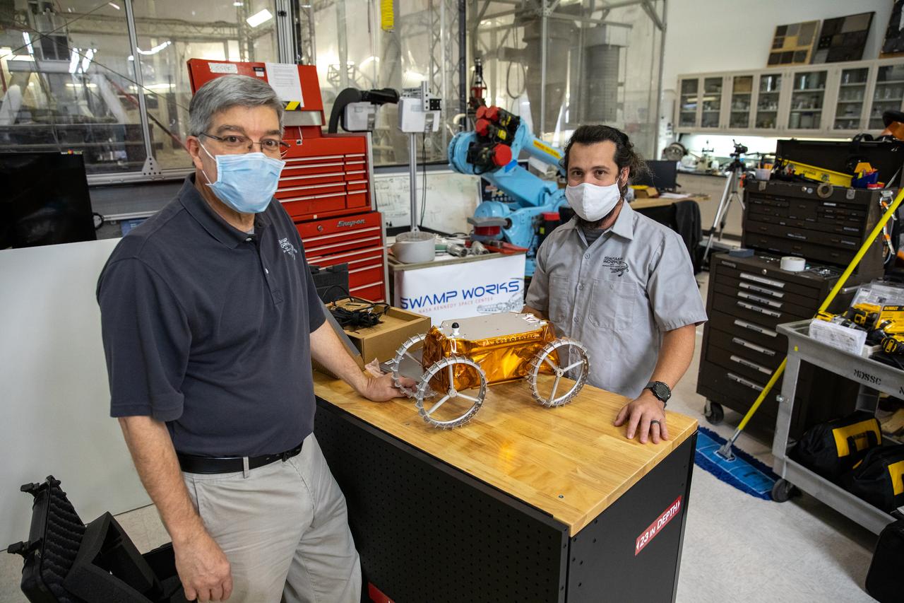 Jim Mantovani, left, and A.J. Nick, with Kennedy Space Center’s Exploration and Research and Technology programs, unbox a CubeRover at the Florida spaceport on Oct. 9, 2020. The rover was delivered by Pittsburgh-based space robotics company Astrobotic, as part of a Small Business Innovative Research (SBIR) award from NASA. Nick will lead CubeRover testing in the coming months in the Granular Mechanics and Regolith Operations (GMRO) Laboratory’s regolith bin, which holds approximately 120 tons of lunar regolith simulant at Kennedy’s Swamp Works. In 2019, NASA announced a $2 million Tipping Point award to develop more mature CubeRover’s payload interfaces and increase its capabilities.