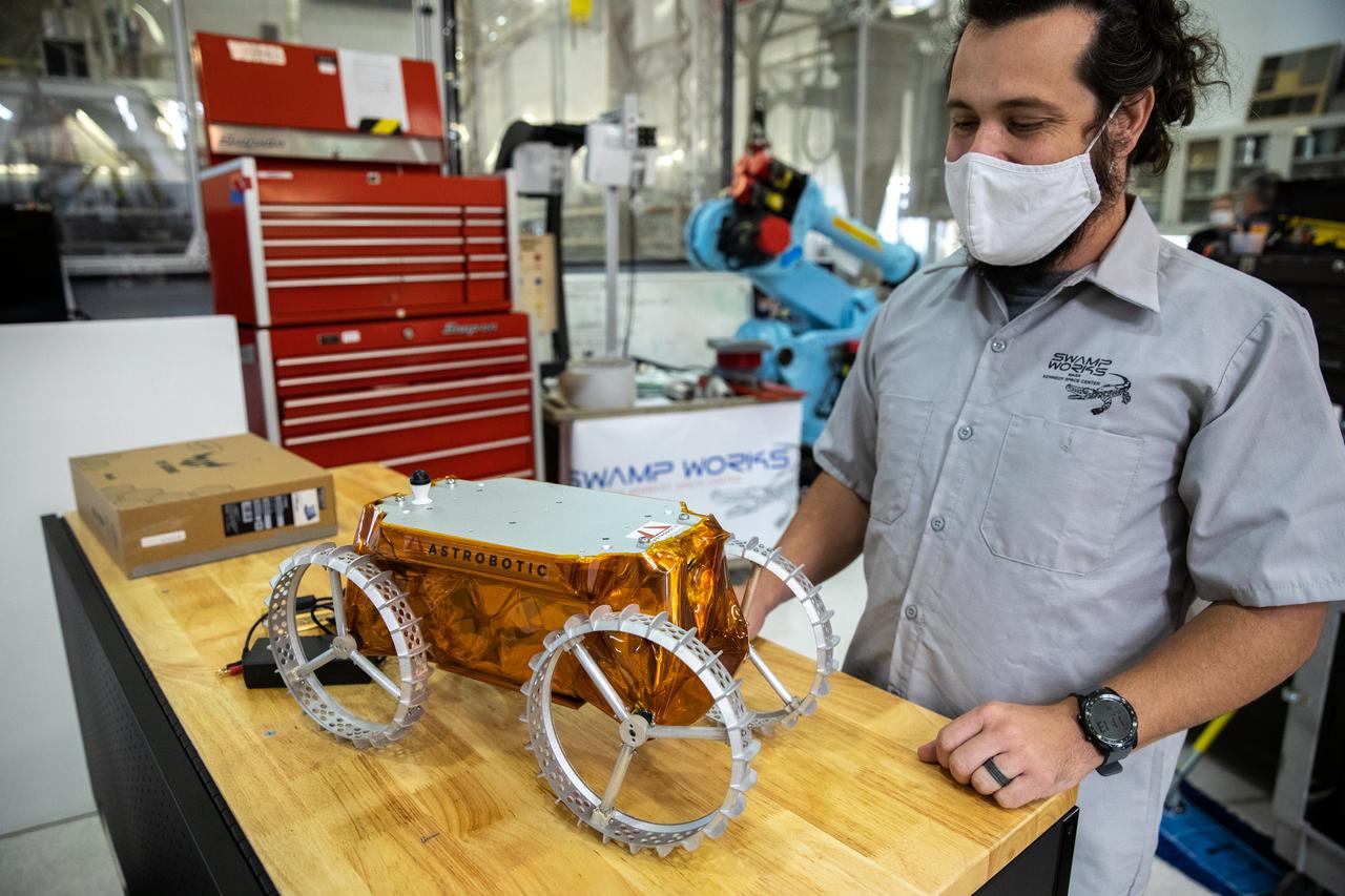 A.J. Nick, with Kennedy Space Center’s Exploration and Research and Technology programs, unboxes a CubeRover at the Florida spaceport on Oct. 9, 2020. The rover was delivered by Pittsburgh-based space robotics company Astrobotic, as part of a Small Business Innovative Research (SBIR) award from NASA. Nick will lead CubeRover testing in the coming months in the Granular Mechanics and Regolith Operations (GMRO) Laboratory’s regolith bin, which holds approximately 120 tons of lunar regolith simulant at Kennedy’s Swamp Works. In 2019, NASA announced a $2 million Tipping Point award to develop more mature CubeRover’s payload interfaces and increase its capabilities.