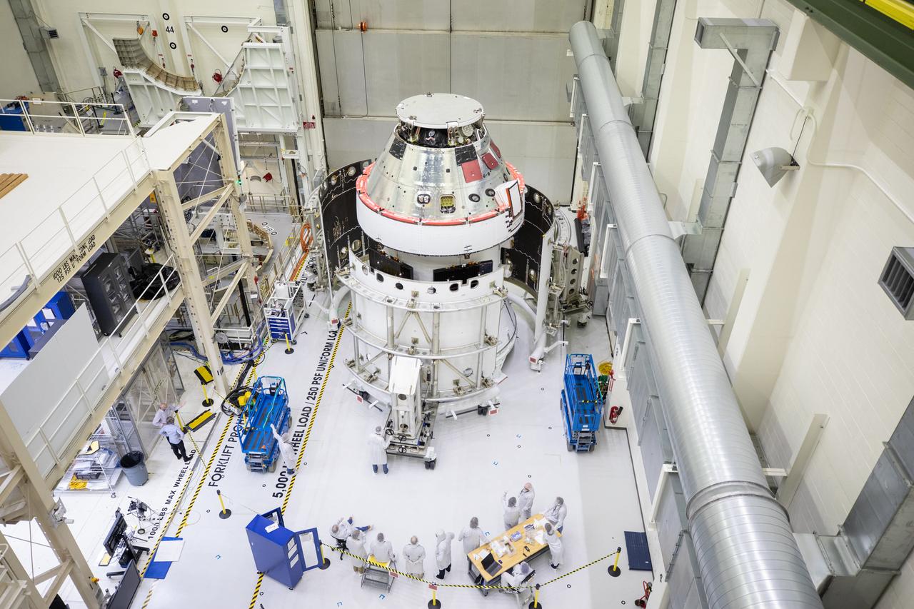 Shown is an overhead view of three spacecraft adapter jettison fairing panels fitted onto Orion’s European Service Module (ESM) on Oct. 13, 2020, inside the Neil Armstrong Operations and Checkout Building (O&C) at NASA’s Kennedy Space Center in Florida. The panels were inspected and moved into place for installation by technicians with Lockheed Martin. Recently, teams from across the globe installed the four solar array wings, which are housed inside the protective covering of the fairings. Once secured, they will encapsulate the ESM to protect it from harsh environments such as heat, wind, and acoustics as the spacecraft is propelled out of Earth’s atmosphere atop the Space Launch System (SLS) rocket during NASA’s Artemis I mission.