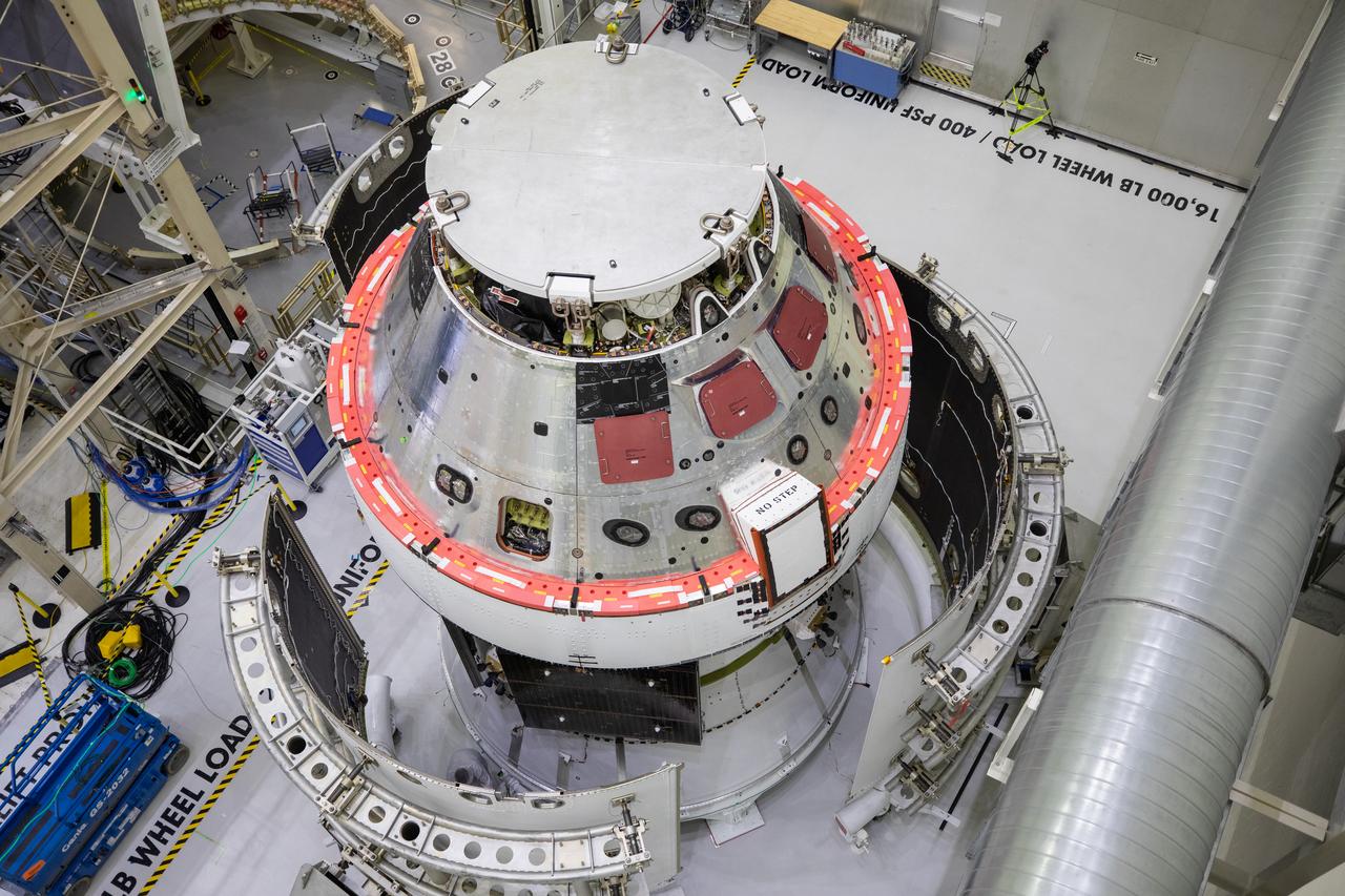 Shown is an overhead view of three spacecraft adapter jettison fairing panels fitted onto Orion’s European Service Module (ESM) on Oct. 13, 2020, inside the Neil Armstrong Operations and Checkout Building (O&C) at NASA’s Kennedy Space Center in Florida. The panels were inspected and moved into place for installation by technicians with Lockheed Martin. Recently, teams from across the globe installed the four solar array wings, which are housed inside the protective covering of the fairings. Once secured, they will encapsulate the ESM to protect it from harsh environments such as heat, wind, and acoustics as the spacecraft is propelled out of Earth’s atmosphere atop the Space Launch System (SLS) rocket during NASA’s Artemis I mission.