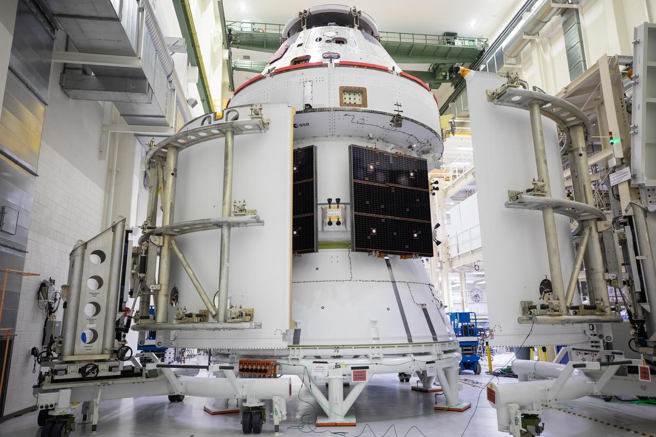 Shown is an overhead view of three spacecraft adapter jettison fairing panels fitted onto Orion’s European Service Module (ESM) on Oct. 13, 2020, inside the Neil Armstrong Operations and Checkout Building (O&C) at NASA’s Kennedy Space Center in Florida. The panels were inspected and moved into place for installation by technicians with Lockheed Martin. Recently, teams from across the globe installed the four solar array wings, which are housed inside the protective covering of the fairings. Once secured, they will encapsulate the ESM to protect it from harsh environments such as heat, wind, and acoustics as the spacecraft is propelled out of Earth’s atmosphere atop the Space Launch System (SLS) rocket during NASA’s Artemis I mission.