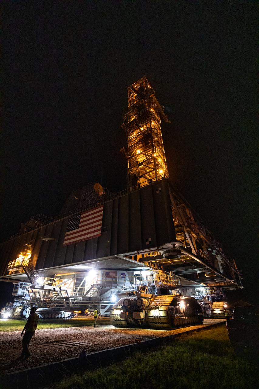 In the early morning on Oct. 20, 2020, the mobile launcher for the Artemis I mission rolls along the crawlerway atop crawler-transporter 2 after departing the Vehicle Assembly Building at NASA’s Kennedy Space Center in Florida. The nearly 400-foot-tall mobile launcher is being rolled to Launch Pad 39B. During its two-week stay at the pad, engineers with Exploration Ground Systems and Jacobs will perform several tasks, including a timing test to validate the launch team’s countdown timeline, and a thorough, top-to-bottom wash down of the mobile launcher to remove any debris remaining from construction and installation of the umbilical arms. Artemis I will test the Orion spacecraft and Space Launch System as an integrated system ahead of crewed flights to the Moon. Under the Artemis program, NASA will land the first woman and the next man on the Moon in 2024.