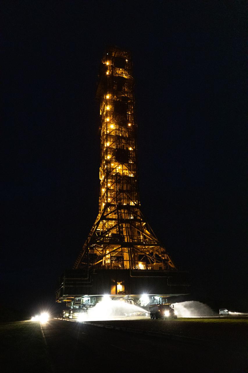 In the early morning on Oct. 20, 2020, the mobile launcher for the Artemis I mission, atop crawler-transporter 2, moves slowly along the crawlerway to Launch Pad 39B at NASA’s Kennedy Space Center in Florida. The nearly 400-foot-tall mobile launcher will remain at the pad for two weeks, while engineers with Exploration Ground Systems and Jacobs will perform several tasks, including a timing test to validate the launch team’s countdown timeline, and a thorough, top-to-bottom wash down of the mobile launcher to remove any debris remaining from construction and installation of the umbilical arms. Artemis I will test the Orion spacecraft and Space Launch System as an integrated system ahead of crewed flights to the Moon. Under the Artemis program, NASA will land the first woman and the next man on the Moon in 2024.