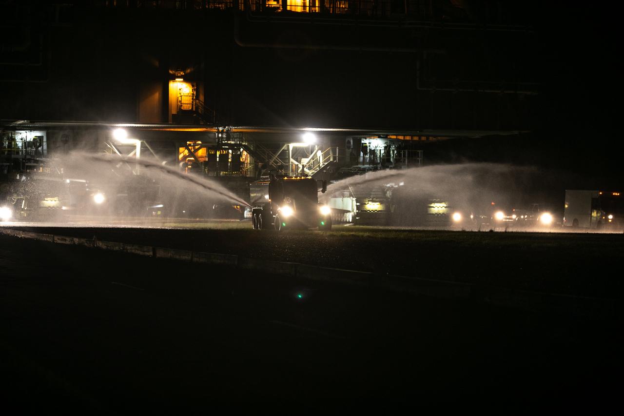 In the early morning on Oct. 20, 2020, a truck sprays water in front of crawler-transporter 2 to reduce dust and bugs, as the mobile launcher for the Artemis I mission rolls slowly along the crawlerway from the Vehicle Assembly Building at NASA’s Kennedy Space Center in Florida. The nearly 400-foot-tall mobile launcher is being rolled to Launch Pad 39B. During its two-week stay at the pad, engineers with Exploration Ground Systems and Jacobs will perform several tasks, including a timing test to validate the launch team’s countdown timeline, and a thorough, top-to-bottom wash down of the mobile launcher to remove any debris remaining from construction and installation of the umbilical arms. Artemis I will test the Orion spacecraft and Space Launch System as an integrated system ahead of crewed flights to the Moon. Under the Artemis program, NASA will land the first woman and the next man on the Moon in 2024.
