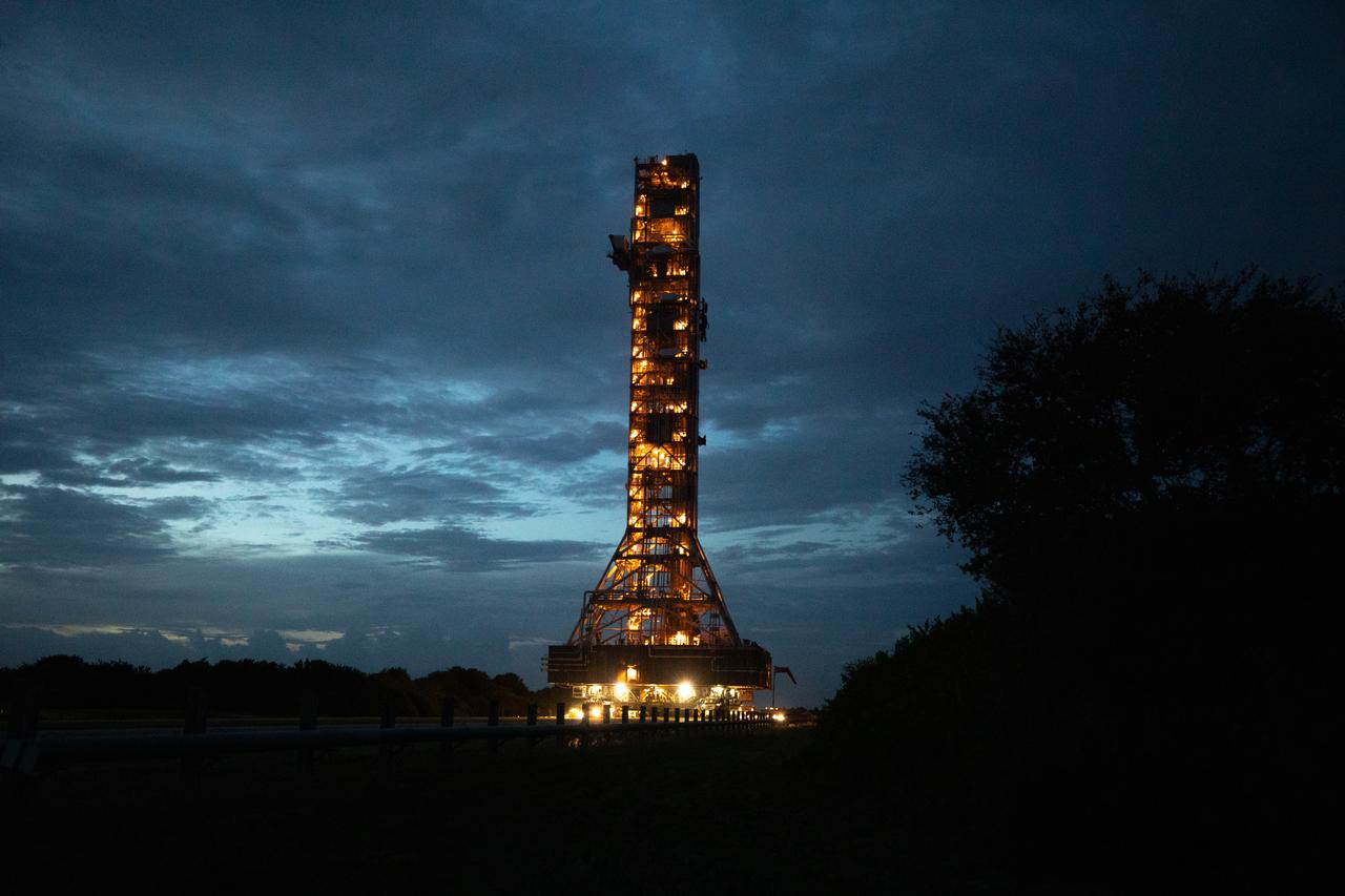 Xenon lights illuminate the mobile launcher for the Artemis I mission, as it is carried slowly along the crawlerway atop crawler-transporter 2 at NASA’s Kennedy Space Center in Florida on Oct. 20, 2020. The nearly 400-foot-tall mobile launcher is being rolled to Launch Pad 39B. During its two-week stay at the pad, engineers with Exploration Ground Systems and Jacobs will perform several tasks, including a timing test to validate the launch team’s countdown timeline, and a thorough, top-to-bottom wash down of the mobile launcher to remove any debris remaining from construction and installation of the umbilical arms. Artemis I will test the Orion spacecraft and Space Launch System as an integrated system ahead of crewed flights to the Moon. Under the Artemis program, NASA will land the first woman and the next man on the Moon in 2024.
