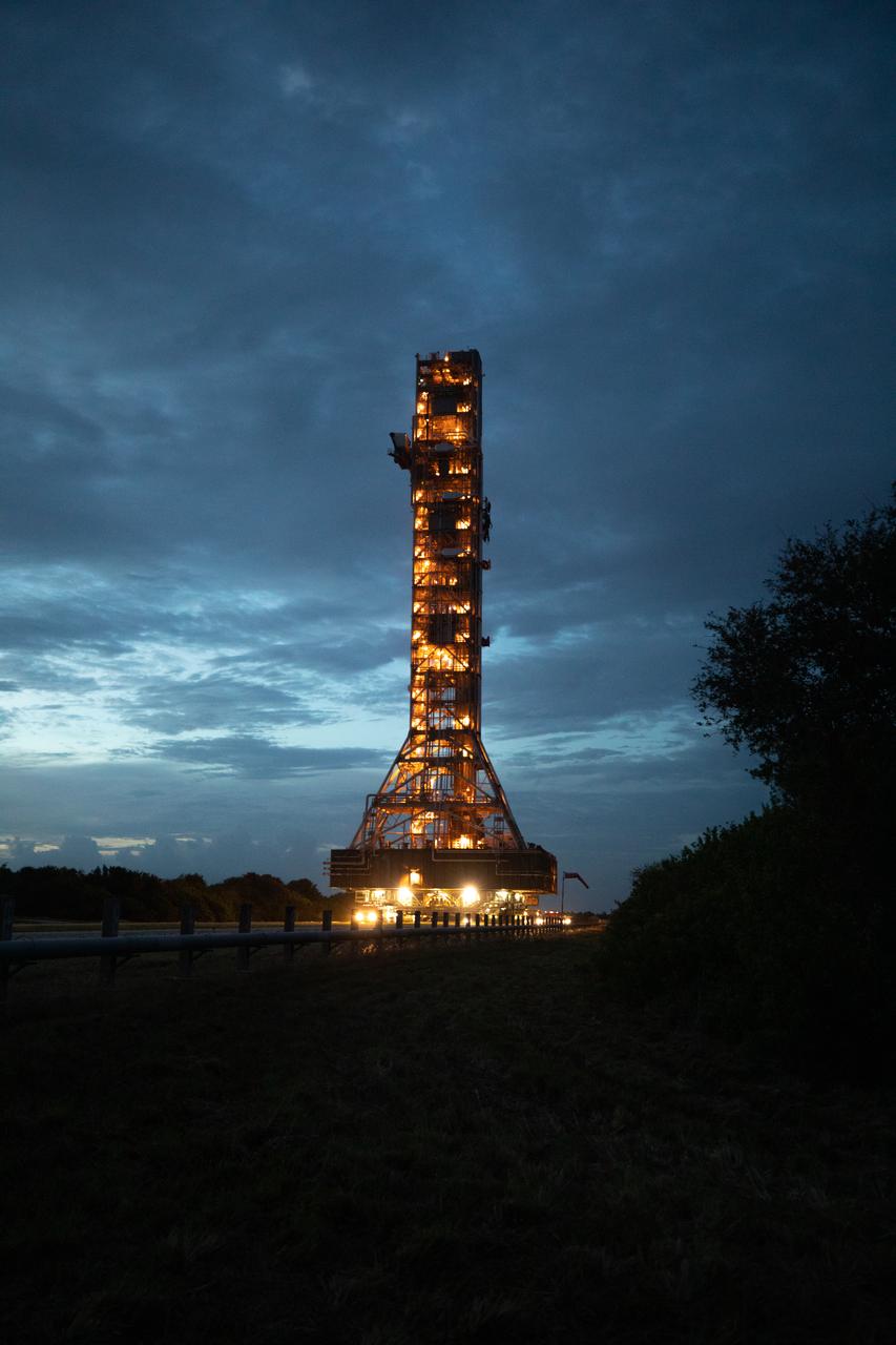 Xenon lights illuminate the mobile launcher for the Artemis I mission, as it is carried slowly along the crawlerway atop crawler-transporter 2 at NASA’s Kennedy Space Center in Florida on Oct. 20, 2020. The nearly 400-foot-tall mobile launcher is being rolled to Launch Pad 39B. During its two-week stay at the pad, engineers with Exploration Ground Systems and Jacobs will perform several tasks, including a timing test to validate the launch team’s countdown timeline, and a thorough, top-to-bottom wash down of the mobile launcher to remove any debris remaining from construction and installation of the umbilical arms. Artemis I will test the Orion spacecraft and Space Launch System as an integrated system ahead of crewed flights to the Moon. Under the Artemis program, NASA will land the first woman and the next man on the Moon in 2024.