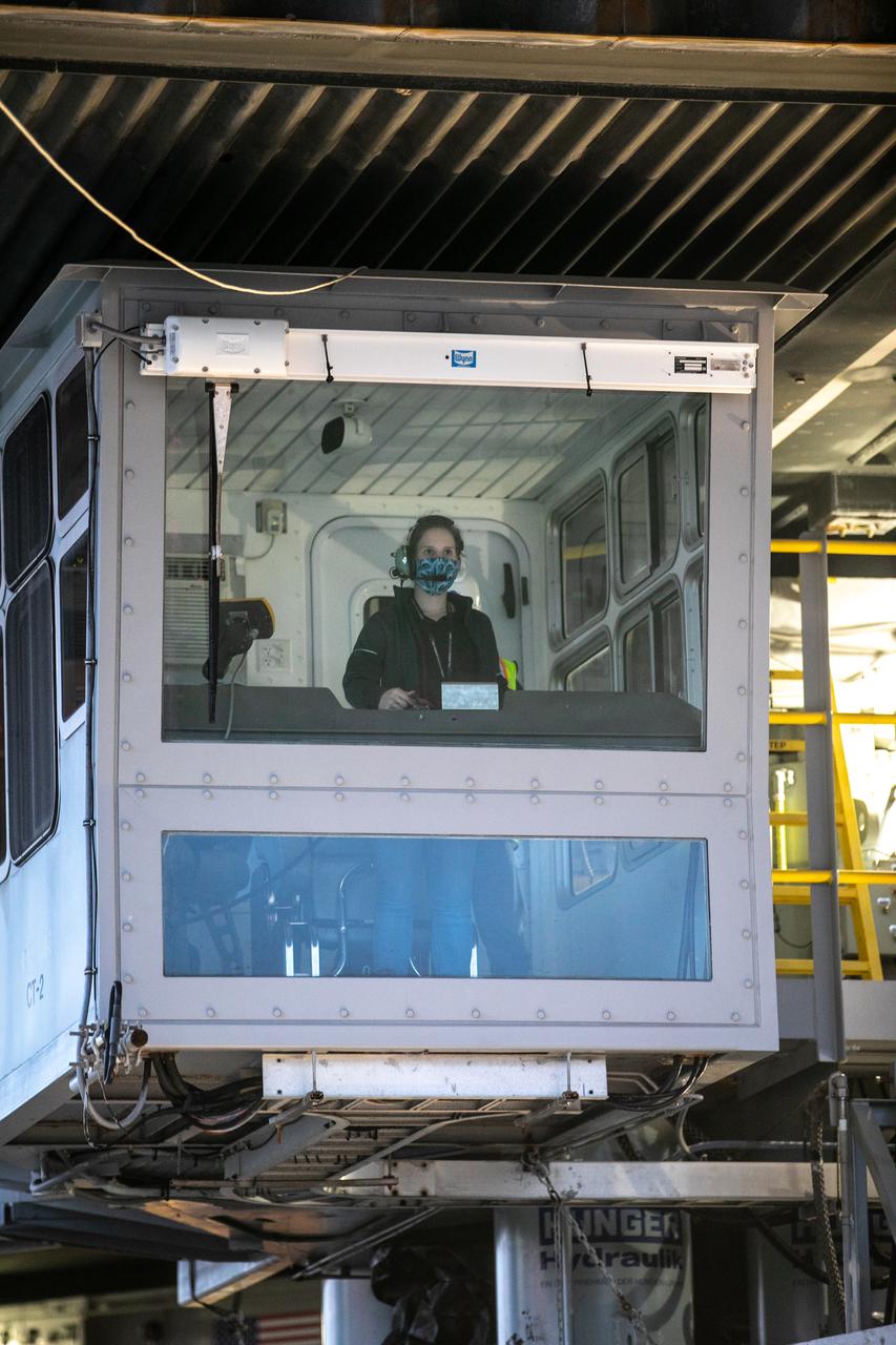During sunrise on Oct. 20, 2020, the mobile launcher for the Artemis I mission, atop crawler-transporter 2 (CT-2), arrives at Launch Pad 39B at NASA’s Kennedy Space Center in Florida. In view inside the CT cab is Breanne Rohloff, crawler-transporter driver and mechanical engineer with Jacobs. The nearly 400-foot-tall mobile launcher will remain at the pad for two weeks, while engineers with Exploration Ground Systems and Jacobs will perform several tasks, including a timing test to validate the launch team’s countdown timeline, and a thorough, top-to-bottom wash down of the mobile launcher to remove any debris remaining from construction and installation of the umbilical arms. Artemis I will test the Orion spacecraft and Space Launch System as an integrated system ahead of crewed flights to the Moon. Under the Artemis program, NASA will land the first woman and the next man on the Moon in 2024.