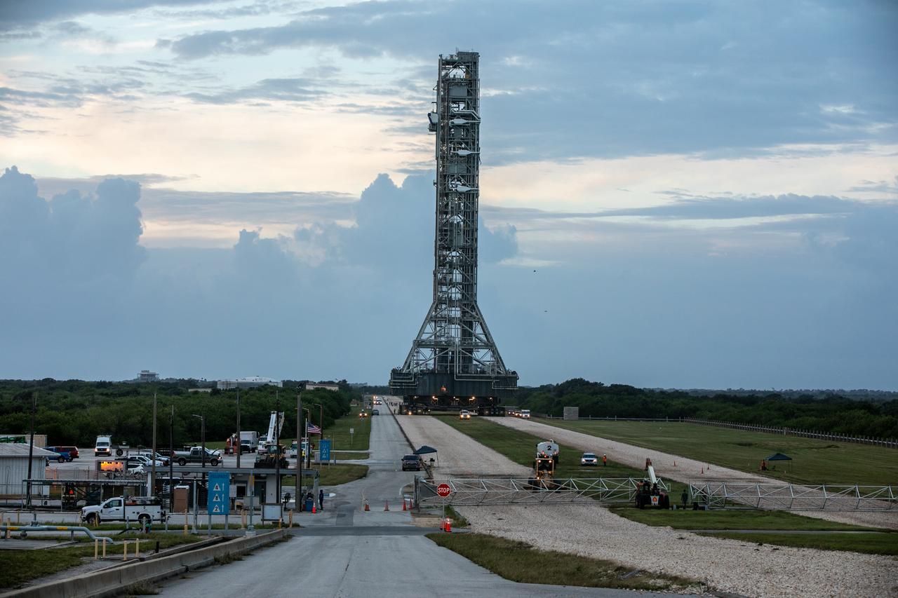 During sunrise on Oct. 20, 2020, the mobile launcher for the Artemis I mission, atop crawler-transporter 2, nears the top of Launch Pad 39B at NASA’s Kennedy Space Center in Florida. The nearly 400-foot-tall mobile launcher will remain at the pad for two weeks, while engineers with Exploration Ground Systems and Jacobs will perform several tasks, including a timing test to validate the launch team’s countdown timeline, and a thorough, top-to-bottom wash down of the mobile launcher to remove any debris remaining from construction and installation of the umbilical arms. Artemis I will test the Orion spacecraft and Space Launch System as an integrated system ahead of crewed flights to the Moon. Under the Artemis program, NASA will land the first woman and the next man on the Moon in 2024.