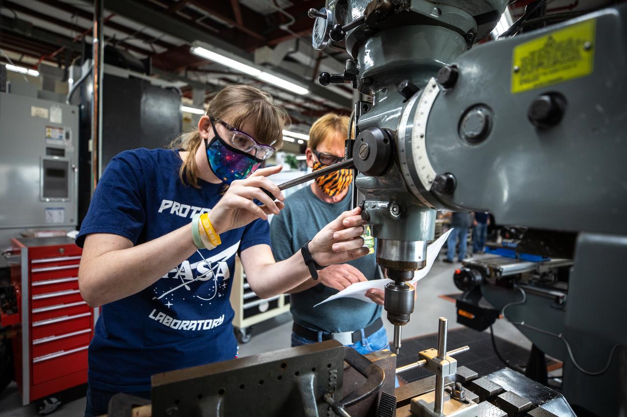 From left, mechanical engineering technicians Katie Mortensen and Jim Niehoff machine test article material inside the Prototype Development Laboratory at NASA’s Kennedy Space Center in Florida on Oct. 21, 2020. The prototype laboratory designs, fabricates, and tests prototypes, test articles and test support equipment. It has a long history of providing fast solutions to complex operations problems. The lab’s teams of engineers use specialized equipment to produce exacting, one-of-a-kind items made from a range of materials depending on the design. The lab supports projects at Kennedy and at the agency level.