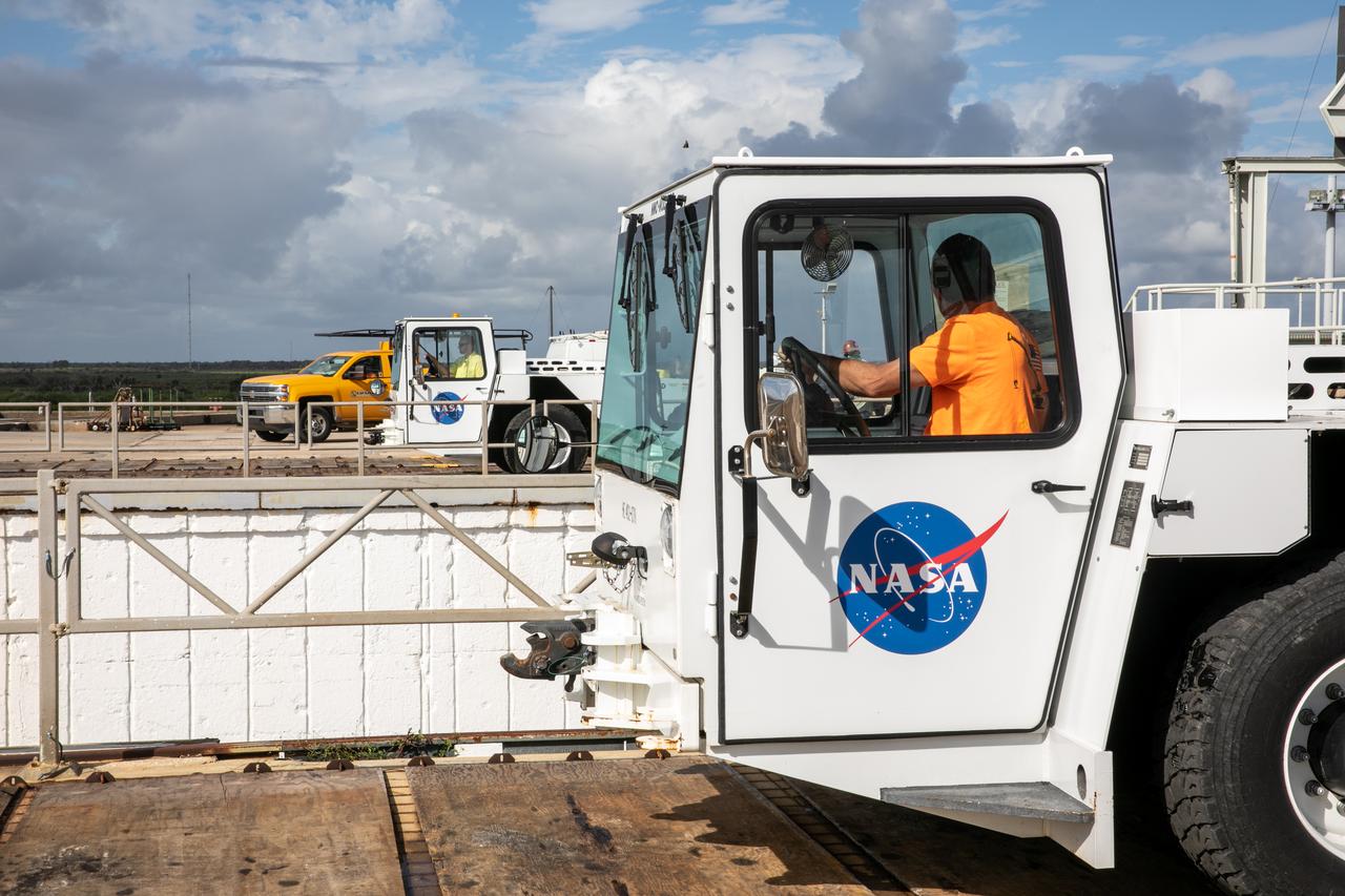 A flatbed carrier is in view on the surface of Launch Pad 39B at NASA’s Kennedy Space Center in Florida on Oct. 23, 2020. It is carrying the engine service platform that was lowered and removed from the mobile launcher for Artemis I. The nearly 400-foot-tall mobile launcher is at the pad while engineers with Exploration Ground Systems and Jacobs complete several tasks, including a timing test to validate the launch team’s countdown timeline, and a thorough, top-to-bottom wash down of the mobile launcher to remove any debris remaining from construction and installation of the umbilical arms. Artemis I will test the Orion spacecraft and Space Launch System as an integrated system ahead of crewed flights to the Moon. Under the Artemis program, NASA will land the first woman and the next man on the Moon in 2024.