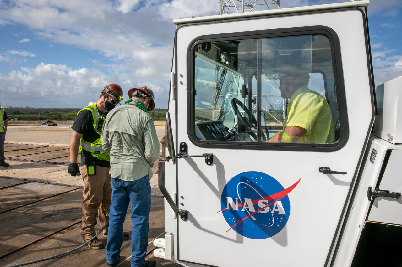 The cab of a flatbed carrier is in view on the surface of Launch Pad 39B at NASA’s Kennedy Space Center in Florida on Oct. 23, 2020. It will carry the engine service platform that was lowered and removed from the mobile launcher for Artemis I. The nearly 400-foot-tall mobile launcher is at the pad while engineers with Exploration Ground Systems and Jacobs complete several tasks, including a timing test to validate the launch team’s countdown timeline, and a thorough, top-to-bottom wash down of the mobile launcher to remove any debris remaining from construction and installation of the umbilical arms. Artemis I will test the Orion spacecraft and Space Launch System as an integrated system ahead of crewed flights to the Moon. Under the Artemis program, NASA will land the first woman and the next man on the Moon in 2024.