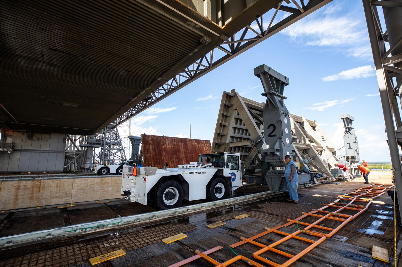 Special ground support equipment is used to move one of two side flame deflectors underneath the mobile launcher for Artemis I during a countdown demonstration test at Launch Pad 39B at NASA’s Kennedy Space Center in Florida on Oct. 23, 2020. The nearly 400-foot-tall mobile launcher is at the pad while engineers with Exploration Ground Systems and Jacobs complete several tasks, including a timing test to validate the launch team’s countdown timeline, and a thorough, top-to-bottom wash down of the mobile launcher to remove any debris remaining from construction and installation of the umbilical arms. Artemis I will test the Orion spacecraft and Space Launch System as an integrated system ahead of crewed flights to the Moon. Under the Artemis program, NASA will land the first woman and the next man on the Moon in 2024.