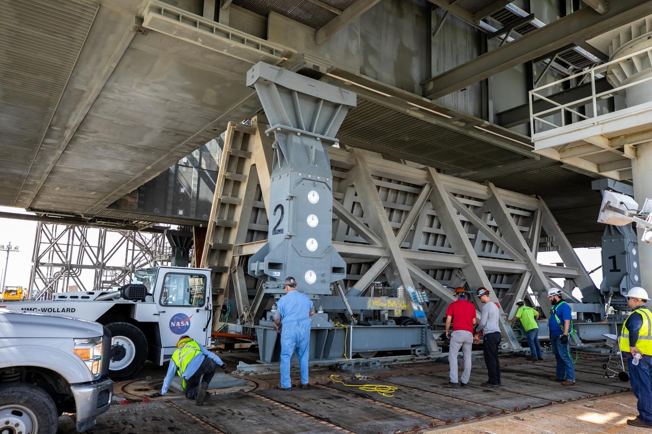 Special ground support equipment is used to move one of two side flame deflectors underneath the mobile launcher for Artemis I during a countdown demonstration test at Launch Pad 39B at NASA’s Kennedy Space Center in Florida on Oct. 23, 2020. The nearly 400-foot-tall mobile launcher is at the pad while engineers with Exploration Ground Systems and Jacobs complete several tasks, including a timing test to validate the launch team’s countdown timeline, and a thorough, top-to-bottom wash down of the mobile launcher to remove any debris remaining from construction and installation of the umbilical arms. Artemis I will test the Orion spacecraft and Space Launch System as an integrated system ahead of crewed flights to the Moon. Under the Artemis program, NASA will land the first woman and the next man on the Moon in 2024.