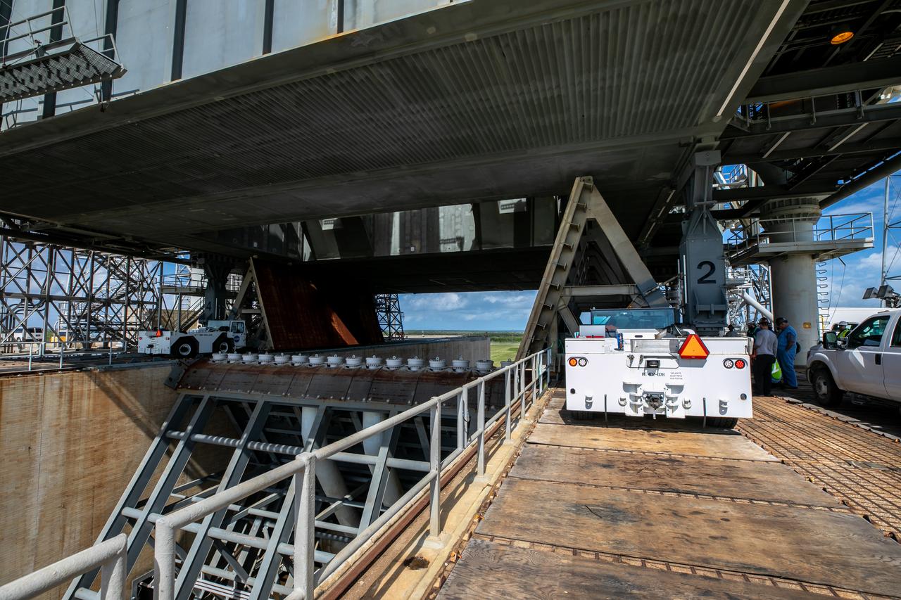 Special ground support equipment is used to move one of two side flame deflectors underneath the mobile launcher for Artemis I during a countdown demonstration test at Launch Pad 39B at NASA’s Kennedy Space Center in Florida on Oct. 23, 2020. The nearly 400-foot-tall mobile launcher is at the pad while engineers with Exploration Ground Systems and Jacobs complete several tasks, including a timing test to validate the launch team’s countdown timeline, and a thorough, top-to-bottom wash down of the mobile launcher to remove any debris remaining from construction and installation of the umbilical arms. Artemis I will test the Orion spacecraft and Space Launch System as an integrated system ahead of crewed flights to the Moon. Under the Artemis program, NASA will land the first woman and the next man on the Moon in 2024.