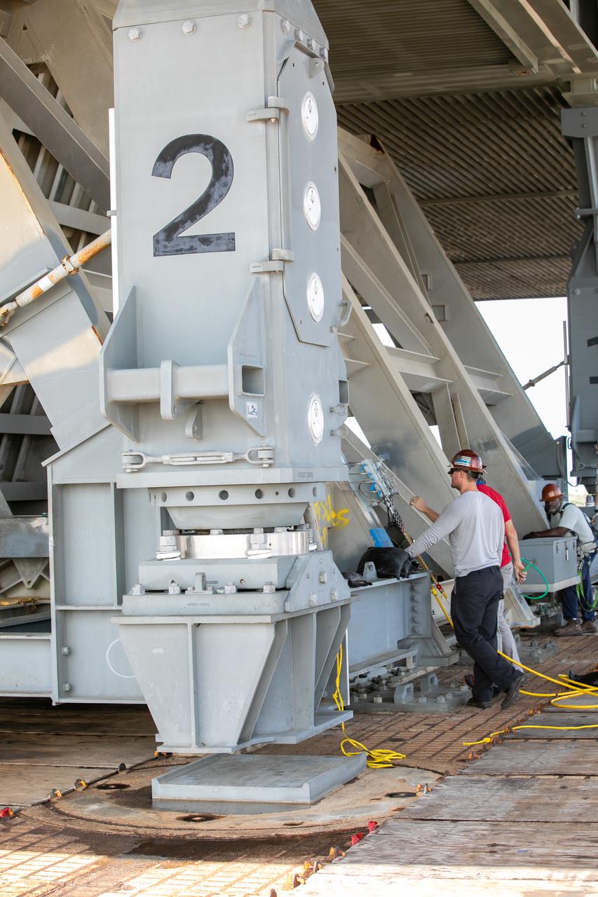 Special ground support equipment is used to position one of two side flame deflectors underneath the mobile launcher for Artemis I during a countdown demonstration test at Launch Pad 39B at NASA’s Kennedy Space Center in Florida on Oct. 23, 2020. The nearly 400-foot-tall mobile launcher is at the pad while engineers with Exploration Ground Systems and Jacobs complete several tasks, including a timing test to validate the launch team’s countdown timeline, and a thorough, top-to-bottom wash down of the mobile launcher to remove any debris remaining from construction and installation of the umbilical arms. Artemis I will test the Orion spacecraft and Space Launch System as an integrated system ahead of crewed flights to the Moon. Under the Artemis program, NASA will land the first woman and the next man on the Moon in 2024.