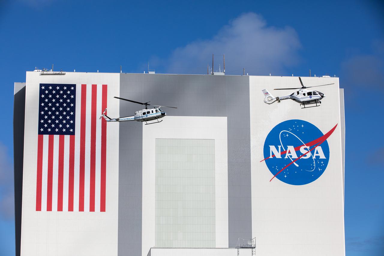 On Oct. 27, 2020, in front of the iconic Vehicle Assembly Building at NASA’s Kennedy Space Center, the Bell Huey 2 (left) and Airbus H135 helicopters used for security operations at the Florida spaceport perform one flight together before the Hueys are retired from their service. The Airbus H135s are replacing the three Bell Huey 2 aircraft maintained by Kennedy’s Flight Operations team. Kennedy received two of the H135 aircraft on Sept. 30, and the third is expected to arrive in spring 2021. These new helicopters provide a number of technological and safety advantages over the Hueys, such as more lifting power, greater stability in the air, and expanded medical capabilities.