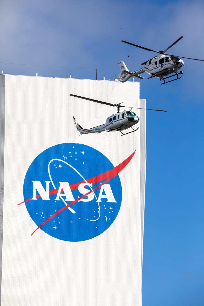 On Oct. 27, 2020, in front of the iconic Vehicle Assembly Building at NASA’s Kennedy Space Center, the Bell Huey 2 (left) and Airbus H135 helicopters used for security operations at the Florida spaceport perform one flight together before the Hueys are retired from their service. The Airbus H135s are replacing the three Bell Huey 2 aircraft maintained by Kennedy’s Flight Operations team. Kennedy received two of the H135 aircraft on Sept. 30, and the third is expected to arrive in spring 2021. These new helicopters provide a number of technological and safety advantages over the Hueys, such as more lifting power, greater stability in the air, and expanded medical capabilities.
