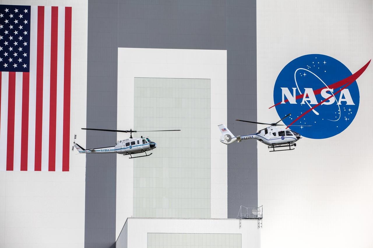 On Oct. 27, 2020, in front of the iconic Vehicle Assembly Building at NASA’s Kennedy Space Center, the Bell Huey 2 (left) and Airbus H135 helicopters used for security operations at the Florida spaceport perform one flight together before the Hueys are retired from their service. The Airbus H135s are replacing the three Bell Huey 2 aircraft maintained by Kennedy’s Flight Operations team. Kennedy received two of the H135 aircraft on Sept. 30, and the third is expected to arrive in spring 2021. These new helicopters provide a number of technological and safety advantages over the Hueys, such as more lifting power, greater stability in the air, and expanded medical capabilities.